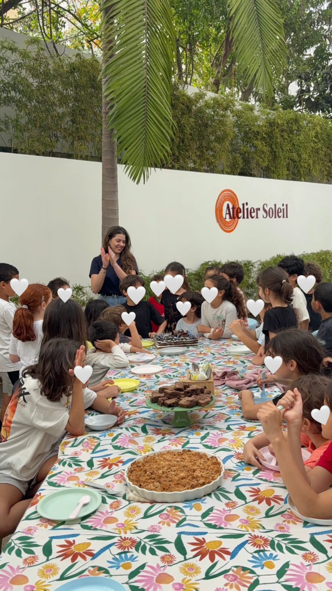 Un groupe d'enfants réunis autour d'une table fleurie à l'Atelier Soleil