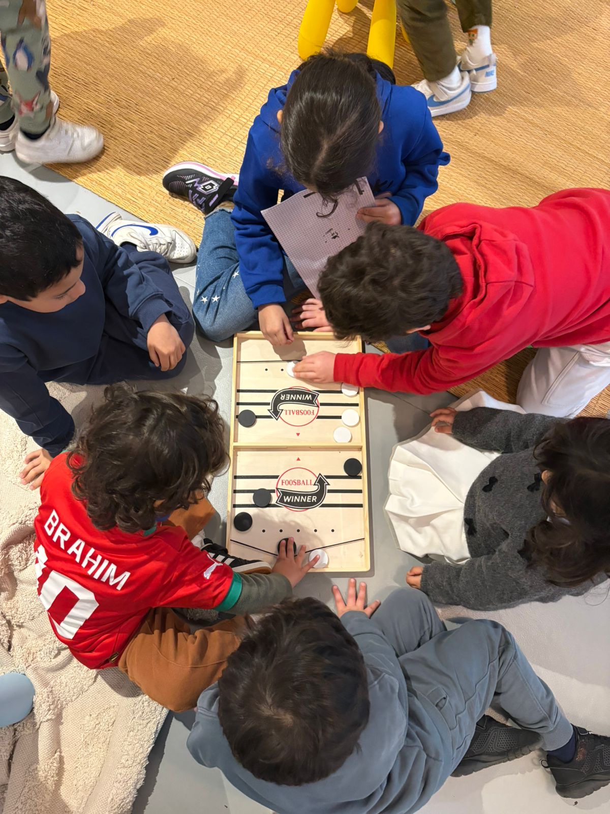 Des enfants participant à un jeu de société en anglais lors du cours d'anglais à Atelier Soleil
