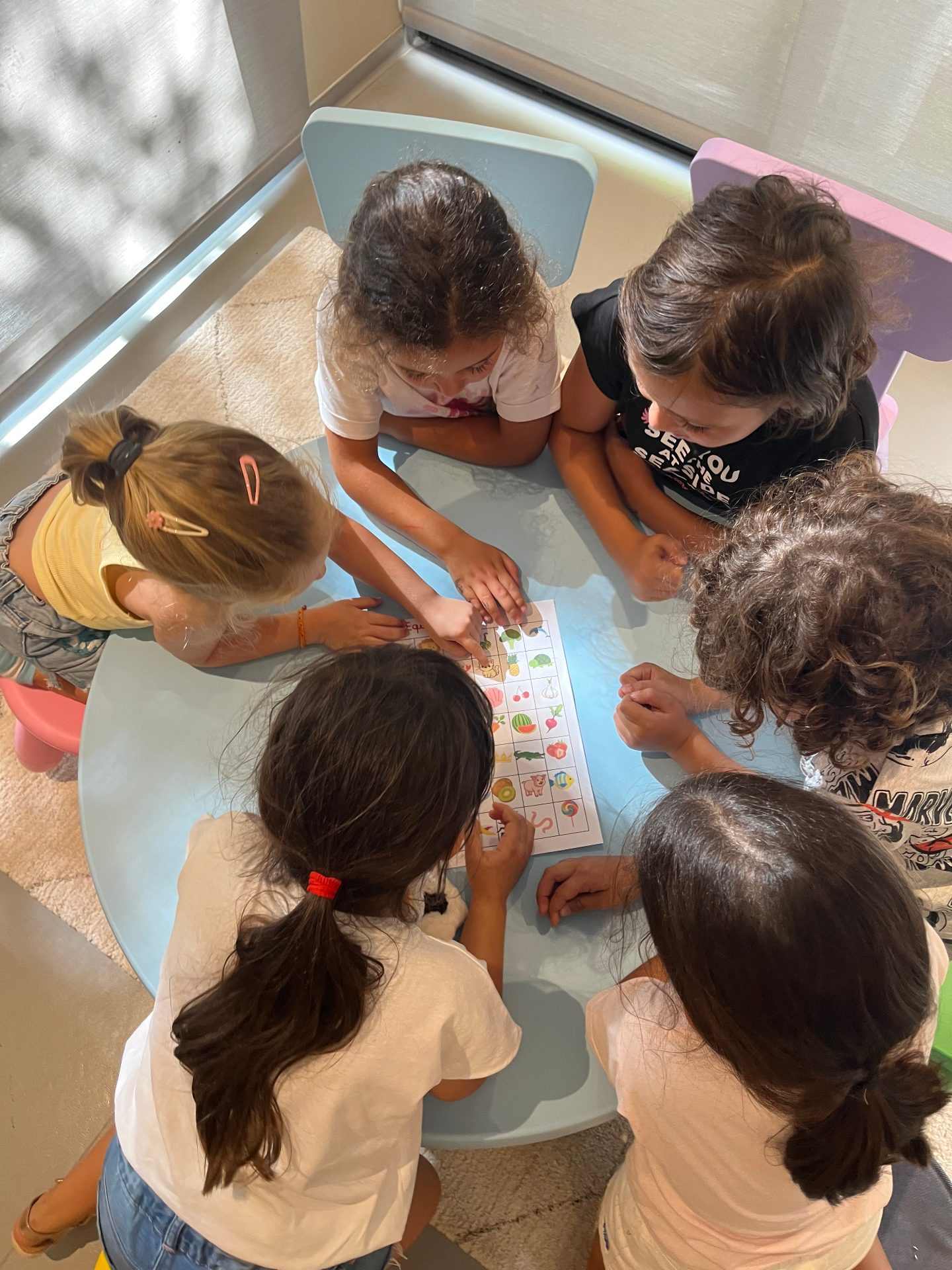 Des enfants rassemblés autour d'une table pour apprendre l'arabe à travers des activités ludiques à Atelier Soleil